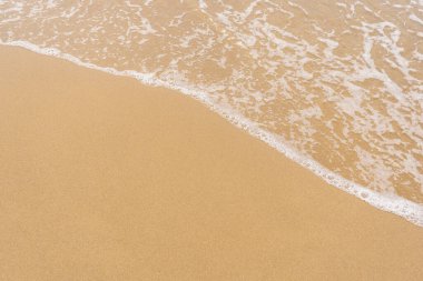 Sahildeki kum ve dalga arkaplanının üst görüntüsü.