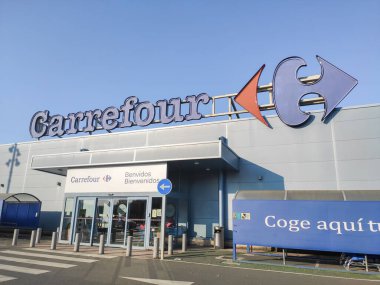Bir CORUNA, İspanya - 24 AUGust, 2021: Carrefour hipermarket ve alışveriş merkezi girişi. Carrefour süpermarketleri, bakkalları ve bakkalları olan çok uluslu bir Fransız perakende şirketidir.
