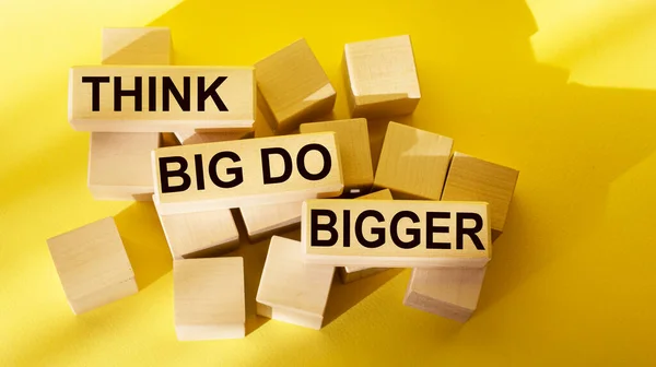 Think Big Do Big Text Written on Wood Blocks and Yellow Background Business Concept Raise the bar and aim much higher