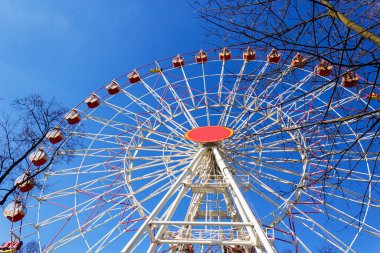 Mavi gökyüzüne karşı parlak renkli dönme dolap.