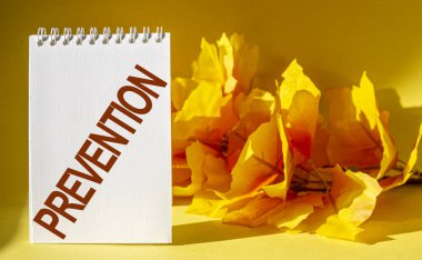 Sarı yapraklı arka plan üzerine önleyici sağlık yazıları yazan tıbbi kelimeler