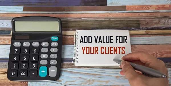 Add Value For Youre Clients ,the text female hand writes in a notebook next to the calculator