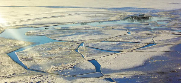 Ice melts on the lake in early spring. Reflection of a clear blue sky in an icy lake