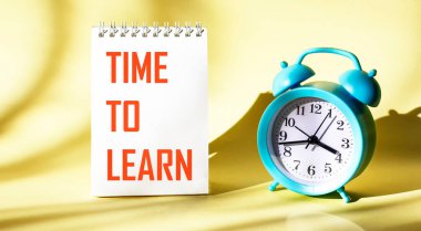 Bir dizüstü bilgisayarın arka planında, Çalar saatin yanında, Öğrenmek için Zaman metni yazılır