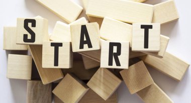 Tahta bloklara beyaz bir arkaplanda Başlat sözcüğü