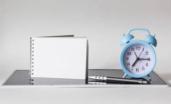 Blanko Notizblock Mit Wecker Stift Auf Schwarzer Spiegelfläche Mit Weißem — Stockfoto