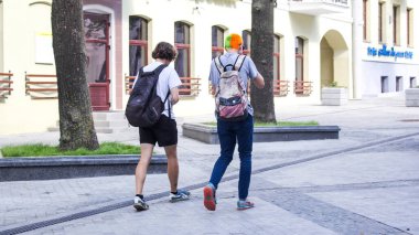 14 Temmuz 2018 'de Minsk' teki Komsomolskaya Caddesi boyunca yürüyorlar. Bir adamın saçları turuncu ve yeşile boyanmış. Hippi.