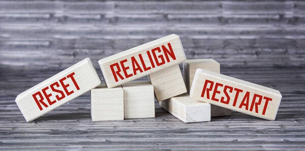 reset, realign, restart concept - abstract words written on wooden blocks