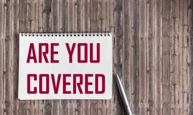 Korunuyorsun. Metin bir deftere yazılmış, tahta bir masadaki kalemin yanına.