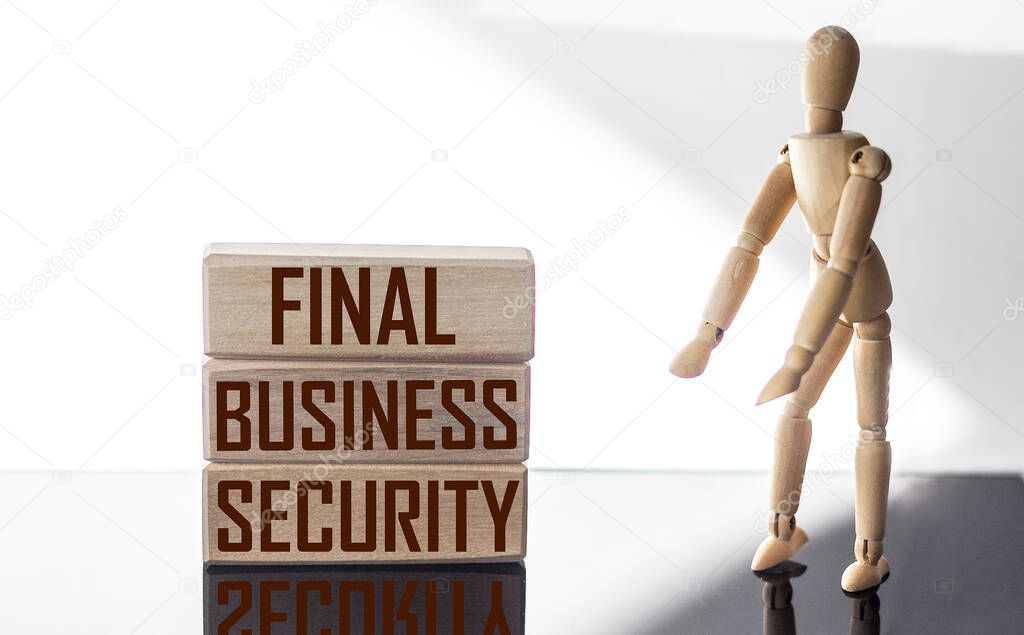 text FINAL BUSINESS SECURITY. The text is written on wooden blocks, on a white and black background with a wooden doll next to it. Business concept.