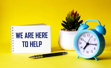 Yardım etmek için buradayız, not defteri ve sarı arkaplan üzerine mesaj, iş konsepti