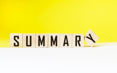 Tahta küpler ve beyaz ve sarı arkaplan üzerine SUMMARY kelimesi