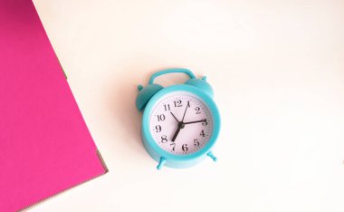 Belgeli pembe klasör ve arka planda alarm saati