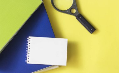 Sarı arka planda belgeler için klasörler, bir büyüteç ve yazmak için bir defter var. Yazılacak yer