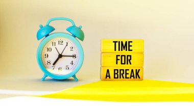 Metni olan tahta bloklar Bir mola için zaman, bir saat ile hafif bir arkaplan üzerinde.