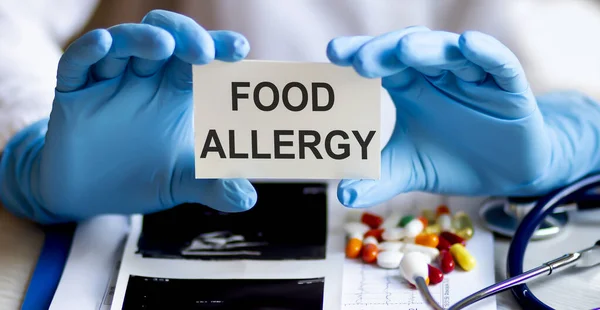 text FOOD ALLERGY write on a medicine card. Medical concept with a stethoscope, pills
