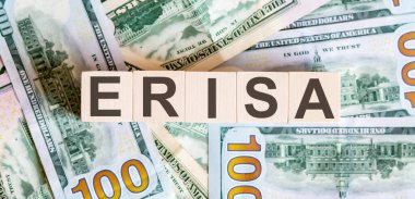Tahta bloklardaki ERISA kelimeleri dolar banknotlarından güzel bir arka planda. İş dünyası