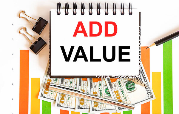 Ноутбук с инструментами и примечаниями о добавлении стоимости, бизнес