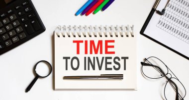 İş konsepti. Not Time to INVEST beyaz kağıt sayfa notlar, hesap makinesi, gözlük, kalem, kalem, beyaz arkaplan