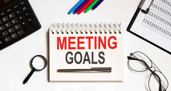 MEETING GOALS text in office notebook with office tools