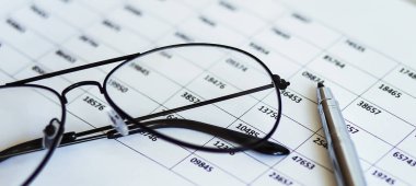 Financial papers with graph and charts ,pen and glasses on the table