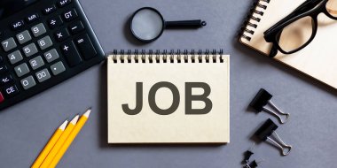 Ofis aletleri ile gri bir arka plan üzerinde yazılar olan not defteri. iş