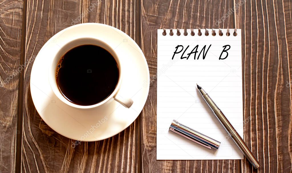 PLAN B - white paper with pen and coffee on wooden background. Business
