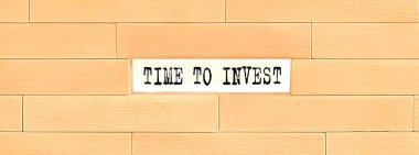 Yatırım zamanı. ahşap blok duvarda metin, iş