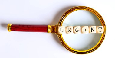 Büyüteç üzerinde metin URGENT ile Tahta Bloklar.