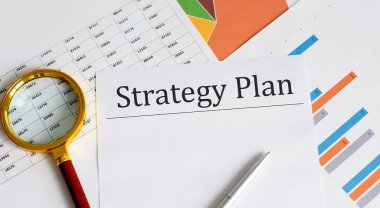 Çizelgede STRATEGY Planı olan kağıt, kalem ve büyüteç, iş