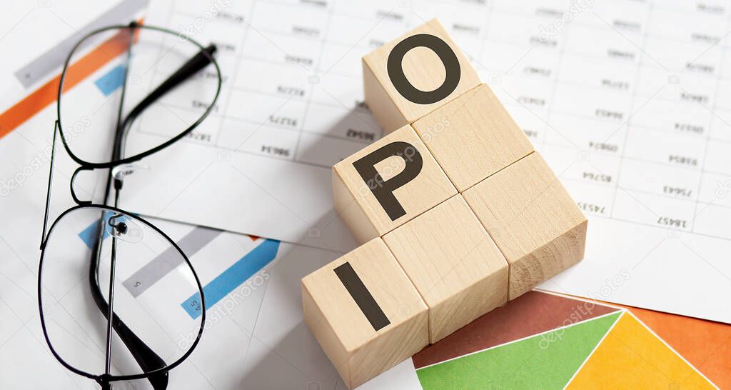 IPO Initial Public Offering written on a wooden cube on charts