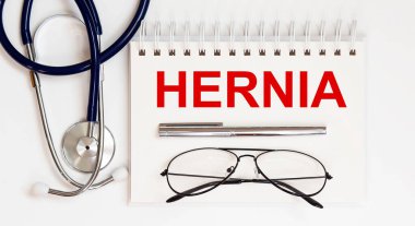 Stetoskop, gözlük ve kalemle beyaz zemin üzerinde bir HERNIA