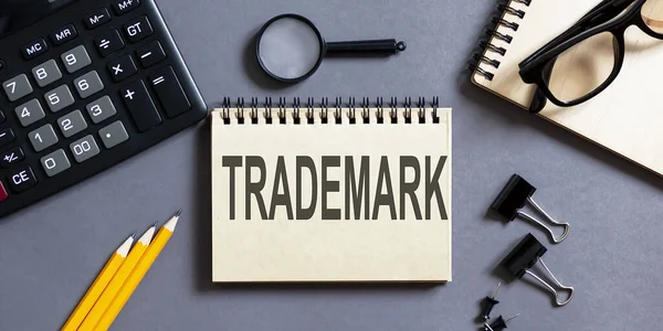 Notizblock Mit Der Aufschrift Trademark Auf Grauem Hintergrund Mit Bürogeräten — Stockfoto