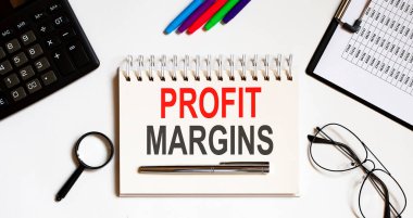 PROFIT MARGIN metin kalem ve ofis araçları ile defter üzerine yazılmış
