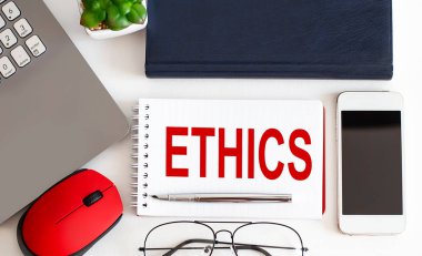 ETHICS text on the notepad,pen, office tools on the white background. Business concept