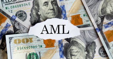 USA dollar with finance text AML on torn piece paper. Business concept