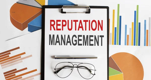 Reputation management text . Conceptual background with chart ,papers, pen and glasses,