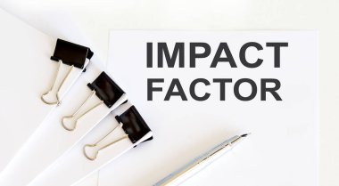 IMPACT FACTOR written on white page with office tools