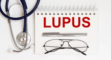 Stetoskop, gözlük ve kalemle beyaz zemin üzerinde bir LUPUS.