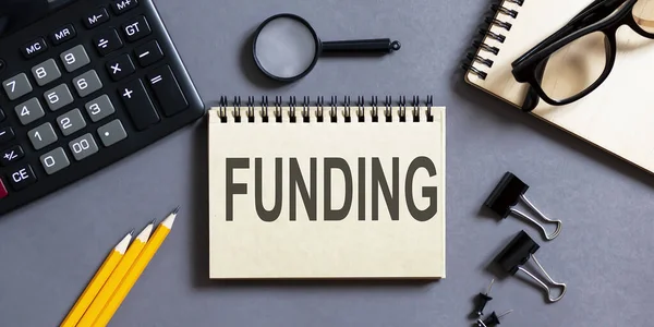 Bloco Notas Com Inscrições Funding Fundo Cinza Com Ferramentas Escritório — Fotografia de Stock