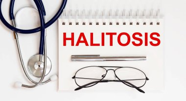 Stetoskop, gözlük ve kalemle beyaz zemin üzerinde bir HALITOSIS.