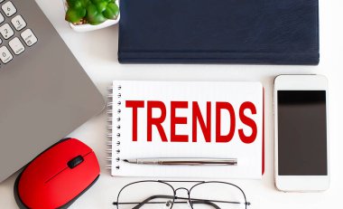 Not defterinde, kaleminde, beyaz arkaplanda TRENDS metni var. İş dünyası