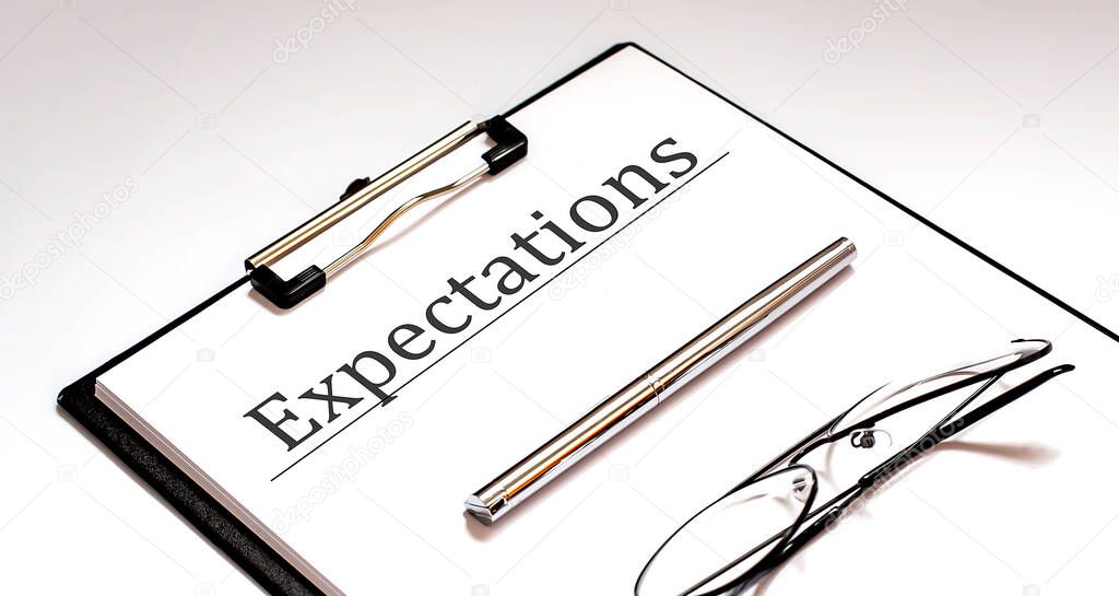 Expectations text written on paper with pen and glasses