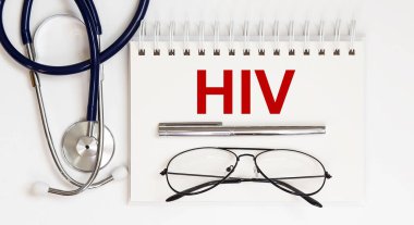 Stetoskop, gözlük ve not defterli kalem beyaz arkaplanda bir HIV.