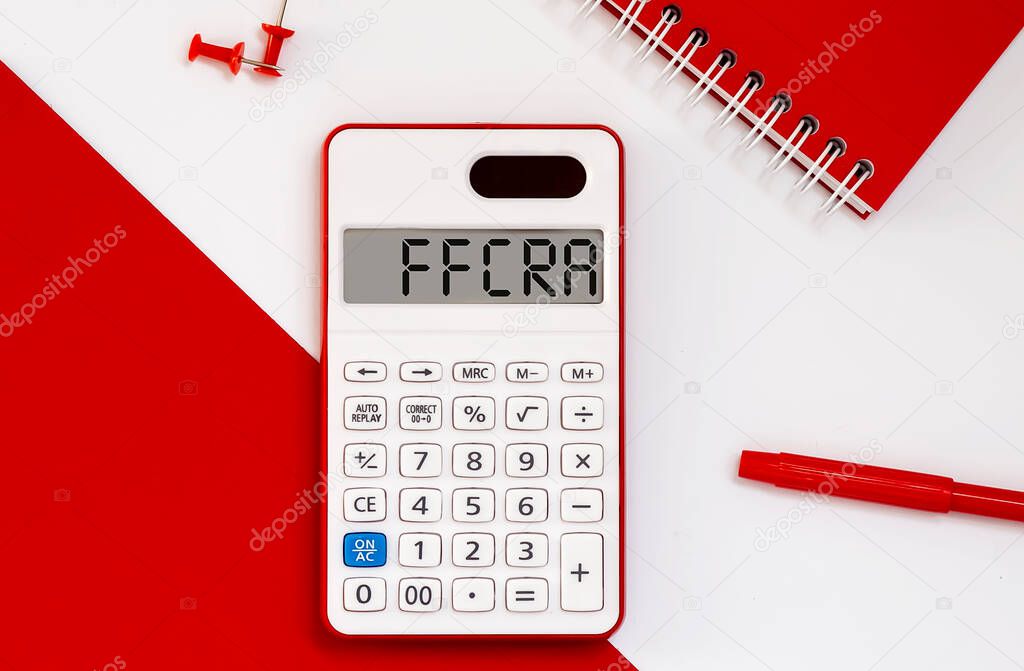 calculator with the word FFCRA on display with red notepad and office tools