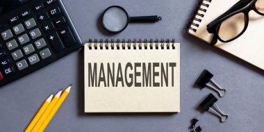 Ofis araçları ile gri bir arka plan üzerinde MANAGEMENT yazıtları ile not. iş