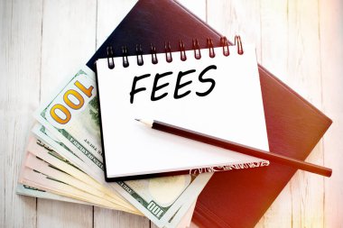 Not defterine dolar banknotları ve kalemle yazılmış ücret metni. Finansal