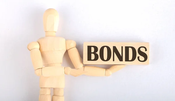 Dřevěný Muž Ukazuje Rukou Blokovat Textem Bonds — Stock fotografie
