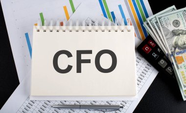 Not defterine çizelge, hesap makinesi ve dolarla yazılmış CFO metni