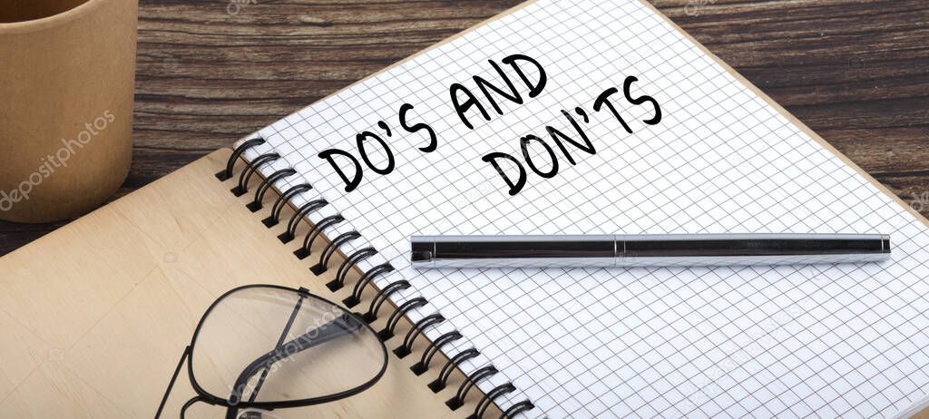 Do's and Don'ts words written in office notebook. Concept in business.